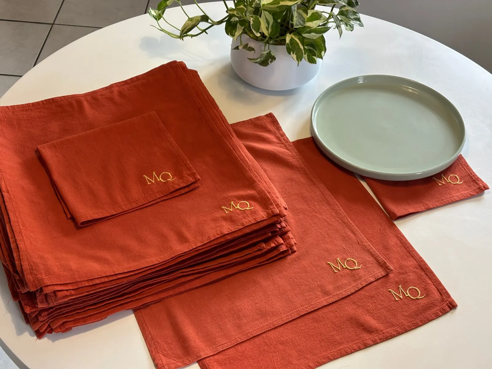 Serviettes de table rouge brique brodées du monogramme MQ en fil doré